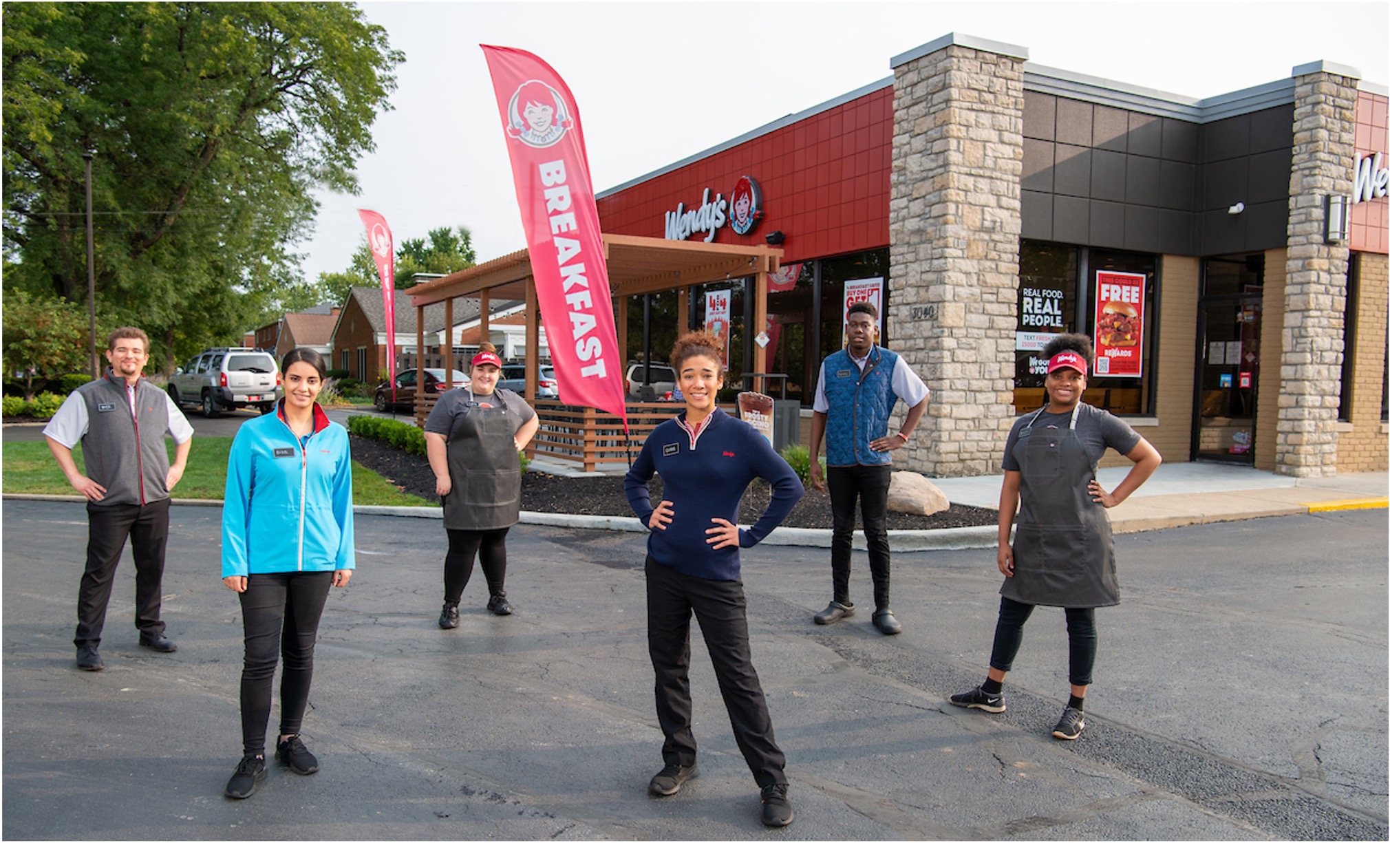 Wendy's crew members outside a Wendy's restaurant